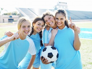 Smiling Female Soccer Players Holding Soccer